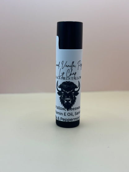 Lip balm tube with black and white label on a light gray background