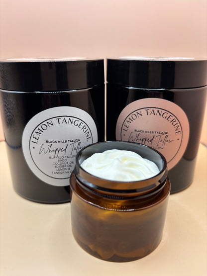 Jar of cream with a black container labeled 'Lemon Tangerine' on a beige background