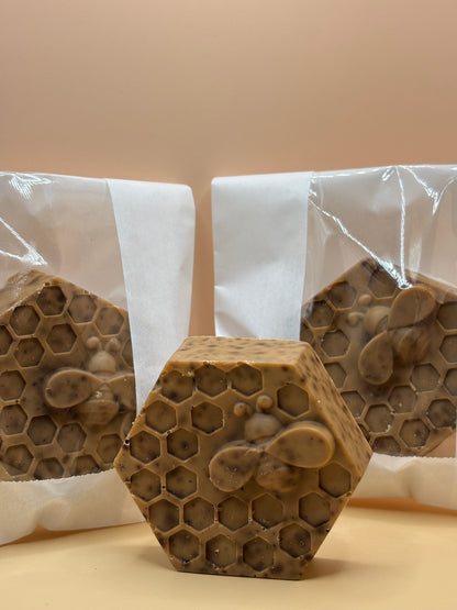 Three honeycomb-shaped soap bars on a white surface with a beige background