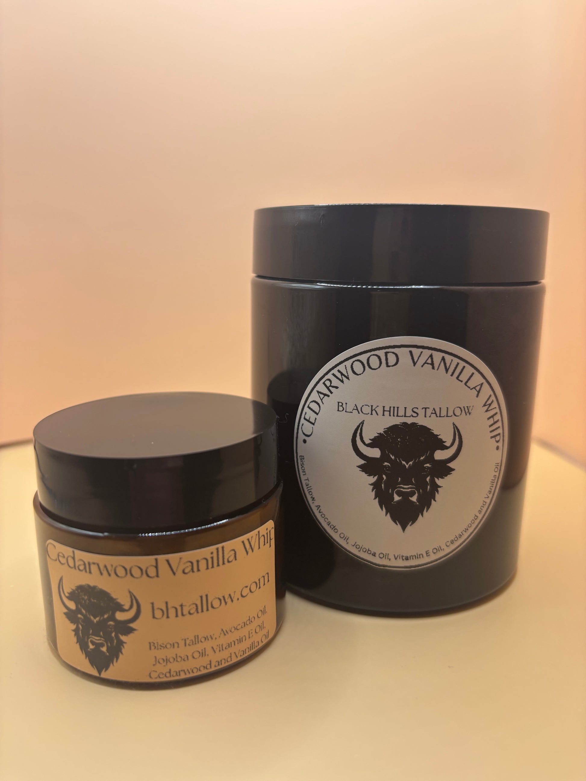 Two black containers with labels featuring a logo on a beige background