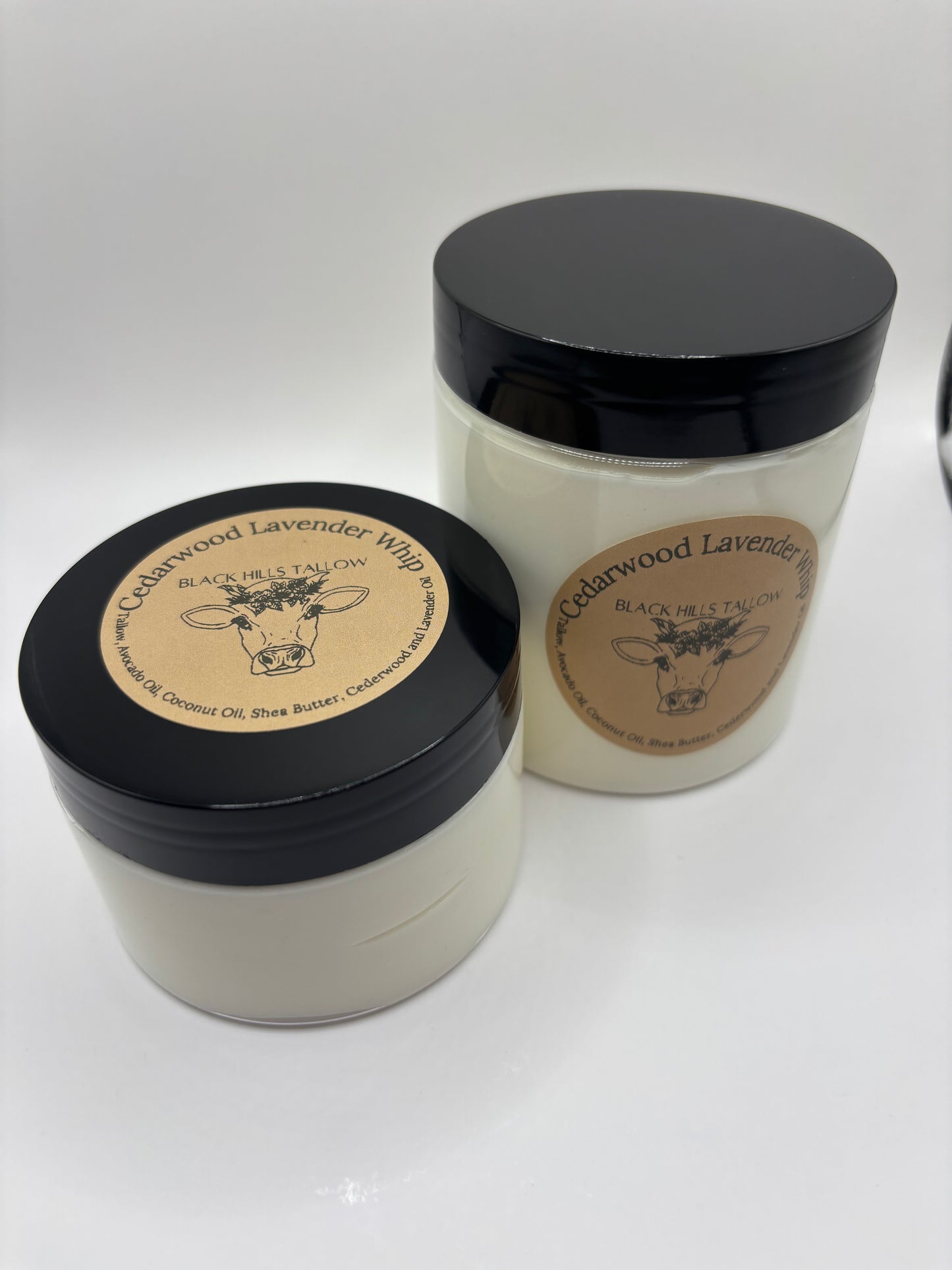 Two containers with black lids and brown labels on a white background